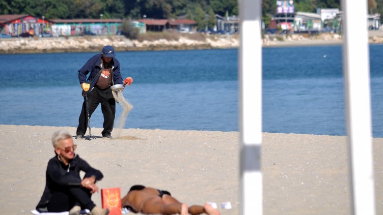 Докато някои се възползват от топлите лъчи на есенното слънце, други &quot;прочистват&quot; плажа. 
